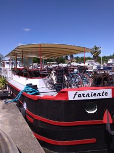a black and red boat with bikes parked on it at PENICHE FARNIENTE CLIMATISEE - Aux Portes de la Camargue in Bellegarde
