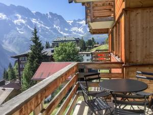 a balcony with a table and chairs and mountains at Apartment Gloria Süd by Interhome in Mürren