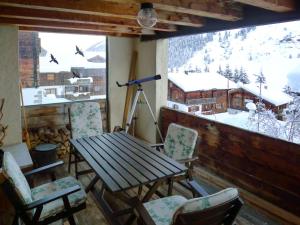 a table and chairs in a room with a view at Apartment Alpetta by Interhome in Tschamut
