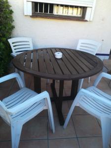 un tavolo in legno con due sedie e una ciotola in cima di Bungalow cerca de la playa a Denia