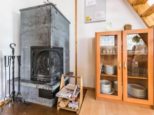 a fireplace in a living room with a cabinet at Holiday Home Aurinkoalppi 10a paritalo price includes by Interhome in Hyrynsalmi