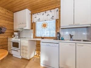 a kitchen with white appliances and a wooden ceiling at Holiday Home Aurinkoalppi 10a paritalo price includes by Interhome in Hyrynsalmi