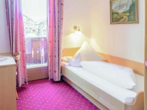 a bedroom with a bed and a window with pink curtains at Apartment Anna by Interhome in Neustift im Stubaital +25 photos