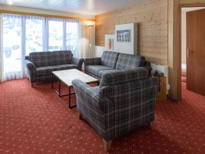 a living room with two couches and a table at Apartment Chalet Abendrot apARTments-32 by Interhome in Grindelwald