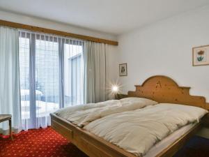 a bedroom with a large bed and a large window at Apartment Chalet Abendrot apARTments-32 by Interhome in Grindelwald