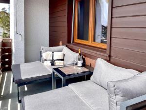 porche con 2 sillas, mesa y ventana en Apartment Lisière-Sud by Interhome en Crans-Montana