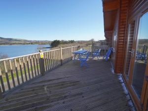 een houten terras met een tafel en stoelen erop bij Chalet Loch Leven Lodge 11 by Interhome in Kinross