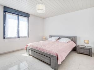 a white bedroom with a bed and a window at Holiday Home Peyroutic by Interhome in Aureilhan