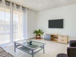 een woonkamer met een tv en een glazen salontafel bij Holiday Home Peyroutic by Interhome in Aureilhan