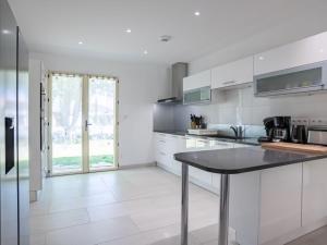 a kitchen with white cabinets and a table at Holiday Home Laouchet by Interhome in Pontenx-les-Forges