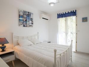a white bedroom with a white bed and a window at Holiday Home Laouchet by Interhome in Pontenx-les-Forges
