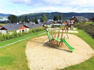 a playground with a green slide in a park at Holiday Home Residence Lipno-1 by Interhome in Lipno nad Vltavou