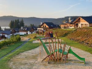 a playground with a slide on a hill with houses at Holiday Home Residence Lipno-1 by Interhome in Lipno nad Vltavou +15 photos