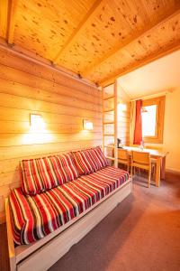 een bed in een houten kamer met een tafel bij Le Panoramix in Plagne 1800