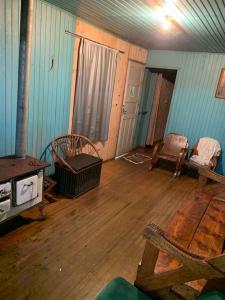a room with a wood floor and a room with a stove at Casa de Campo Cambará in Cambara do Sul