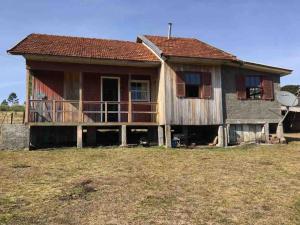 a house that is sitting in a field at Casa de Campo Cambará in Cambara do Sul