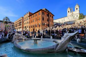 a group of people sitting around a fountain in a city at Vantaggio in Rome