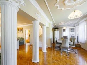une salle à manger avec des colonnes blanches et une table dans l'établissement Villa Big Thuja by Interhome, à Balatonföldvár