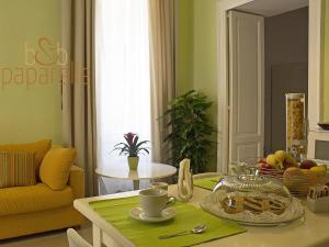 sala de estar con mesa y sofá amarillo en B&B Paparelle, en Cosenza