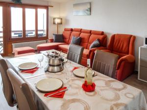 a dining room with a table and a couch at Apartment Derborence 28 by Interhome in Nendaz