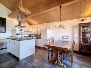 a kitchen with a wooden table and a dining room at Chalet Le Dahu by Interhome in Veysonnaz