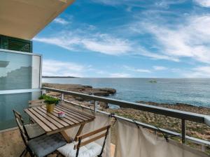 een balkon met een tafel en stoelen en de oceaan bij Apartment Apartment S'Illot-Cala Morlanda by Interhome in S'Illot