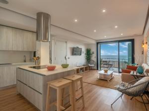 een keuken en een woonkamer met uitzicht op de oceaan bij Apartment Apartment S'Illot-Cala Morlanda by Interhome in S'Illot