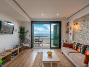 a living room with a couch and a view of the ocean at Apartment S'Illot-Cala Morlanda by Interhome in S'Illot +18 photos