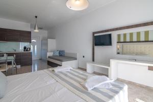 a bedroom with a large bed and a kitchen at Mythos Apartments in Damnoni