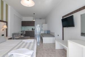 a living room with a bed and a kitchen at Mythos Apartments in Damnoni
