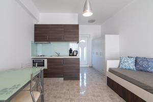 ダンノニにあるMythos Apartmentsのベッド1台、キッチンが備わる小さなアパートメントです。