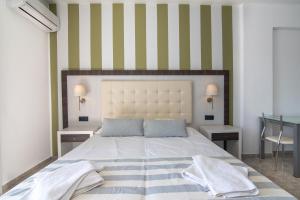 a bedroom with a large bed with a striped wall at Mythos Apartments in Damnoni