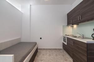 a kitchen with a bed in the middle of it at Mythos Apartments in Damnoni