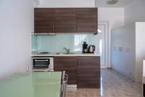 a kitchen with wooden cabinets and a counter top at Mythos Apartments in Damnoni