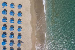 an overhead view of a beach with umbrellas and the ocean at Mythos Apartments in Damnoni