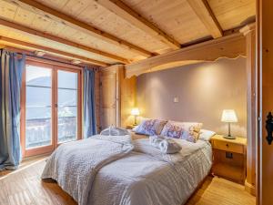 a bedroom with a bed and a large window at Apartment Chalet le Riad des Neiges a- Sauna by Interhome in Val-d'Illiez