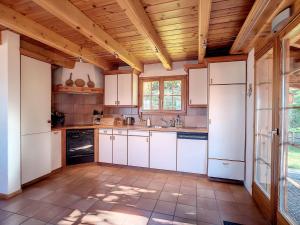 a kitchen with white cabinets and a wooden ceiling at Chalet Les 4 Saisons by Interhome in Veysonnaz