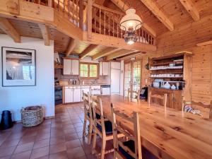 ヴェゾナにあるChalet Les 4 Saisons by Interhomeの木製のテーブルと椅子のある広いキッチン