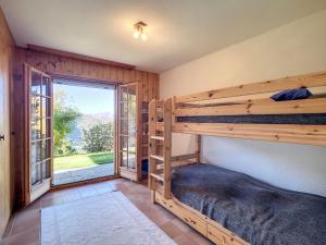 a bedroom with two bunk beds and a large window at Chalet Les 4 Saisons by Interhome in Veysonnaz