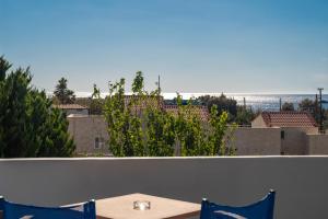 a table and chairs on a balcony with a view of the ocean at Mythos Apartments in Damnoni
