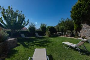 a yard with chairs and a table in the grass at Mythos Apartments in Damnoni