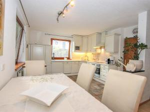 a kitchen with a table and chairs and a kitchen with white cabinets at Apartment Evelyne by Interhome in Zirl