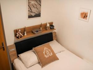 a bedroom with a bed with a wooden head board at Apartment Grande-Ourse 2 pièces 1027 by Interhome in Moleson