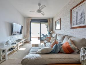 ein Wohnzimmer mit einem Sofa und einem TV in der Unterkunft Apartment Alamar by Interhome in Mijas Costa