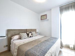 ein weißes Schlafzimmer mit einem Bett und einem Fenster in der Unterkunft Apartment Alamar by Interhome in Mijas Costa