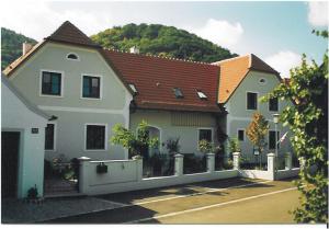 een groot wit huis met een hek ervoor bij Landhaus Rossatz in Rossatz
