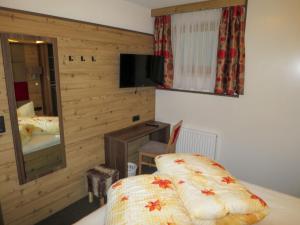 um quarto com uma cama, uma televisão e um espelho em Apartment Alpenflora by Interhome em Kappl