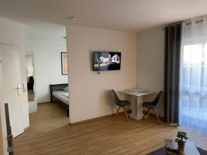 a living room with a table and chairs and a bed at Casa Blanca am Herzzentrum Lahr in Lahr