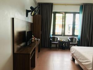 a hotel room with a bed and a flat screen tv at ANH ANH HOTEL in Bắc Hà
