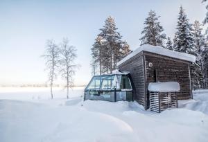 un bus enneigé garé à côté d'un bâtiment dans l'établissement Ranua Resort Arctic Igloos, à Ranua